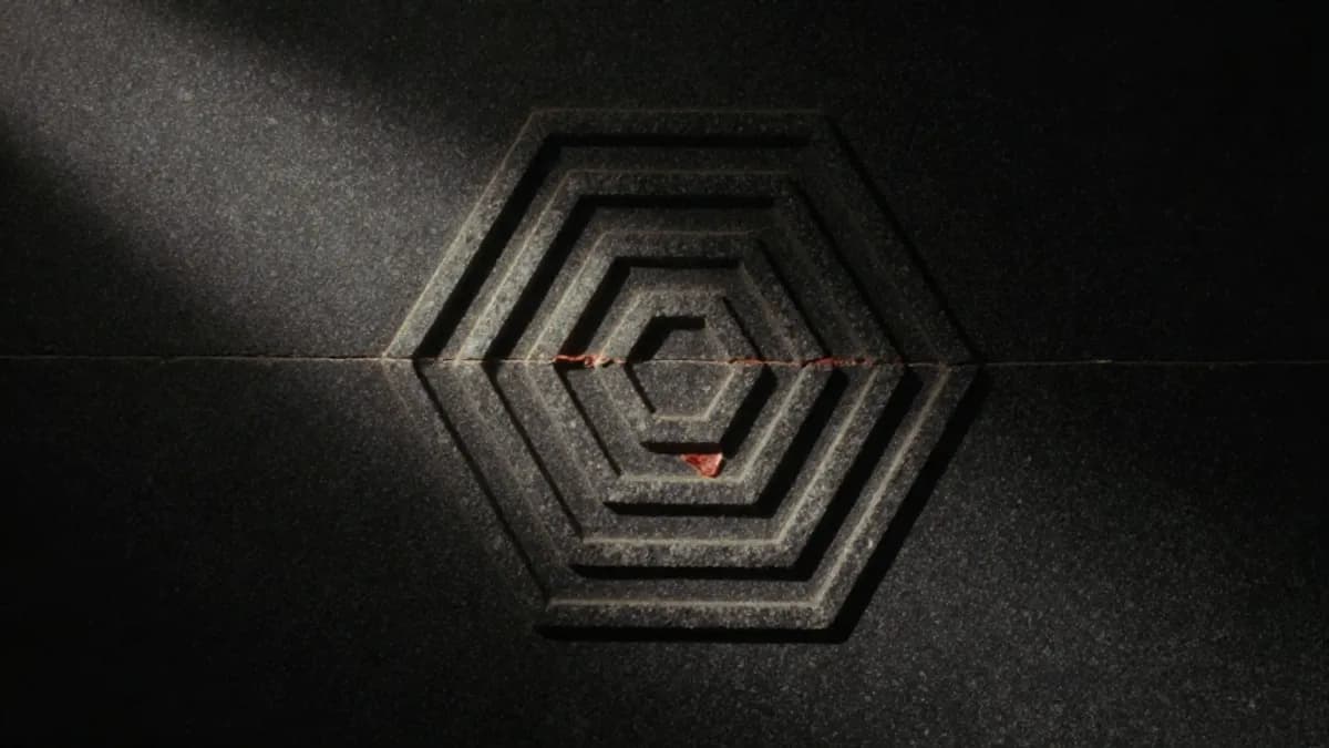 A hexagram carved into ancient black stone, illuminated by a single shaft of light