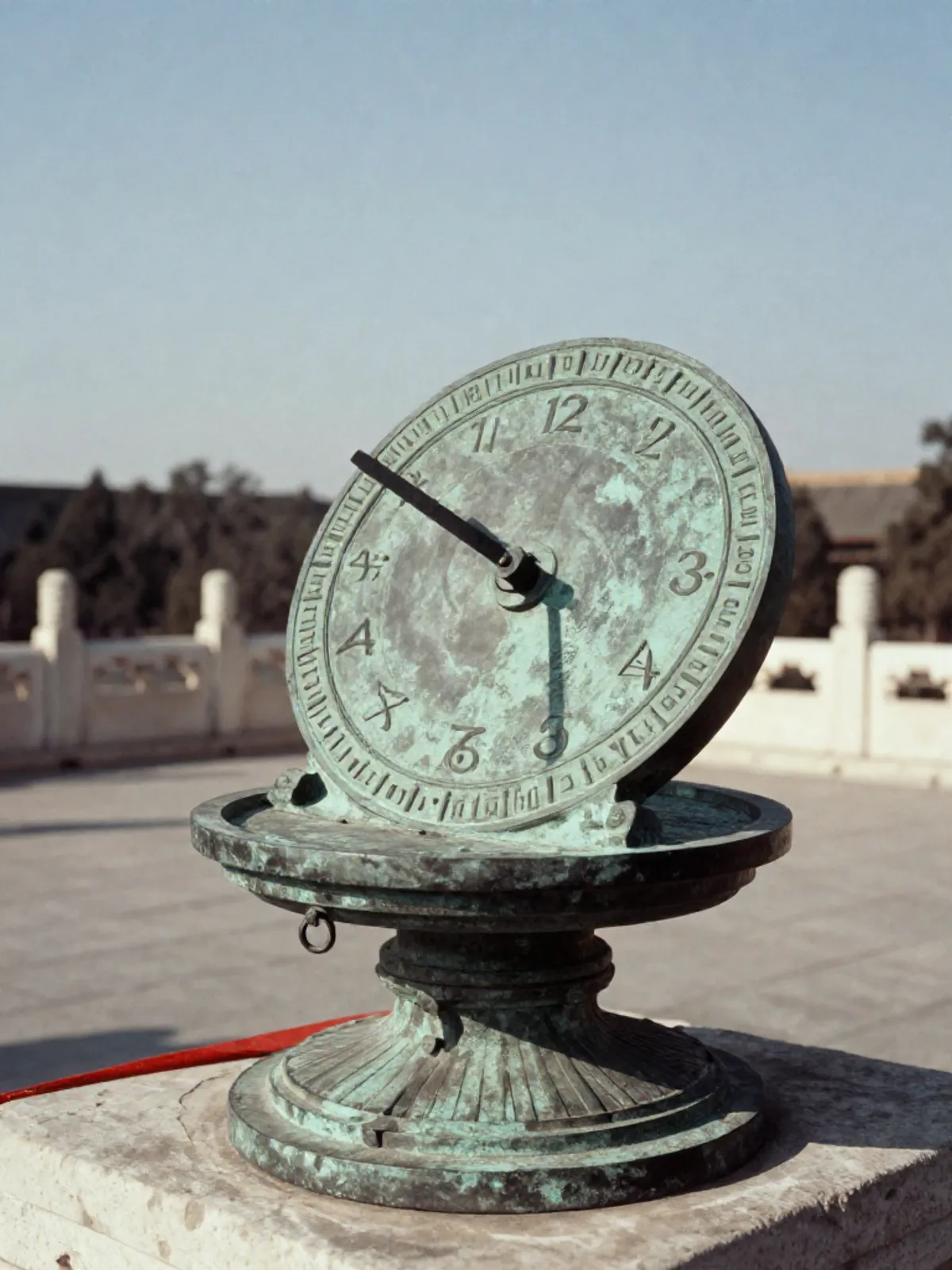 A bronze sundial showing the twelve hours, noon light on the Horse hour